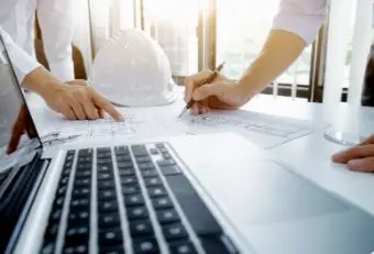Profissionais de engenharia discutindo planos em uma mesa